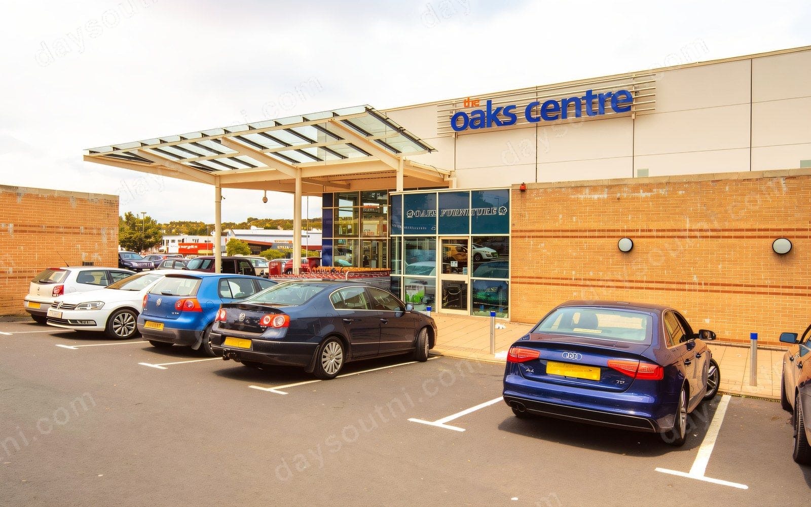 The Oaks Centre in Dungannon seen from the car park, the blue 'the oaks centre' sign over the covered glass entrance