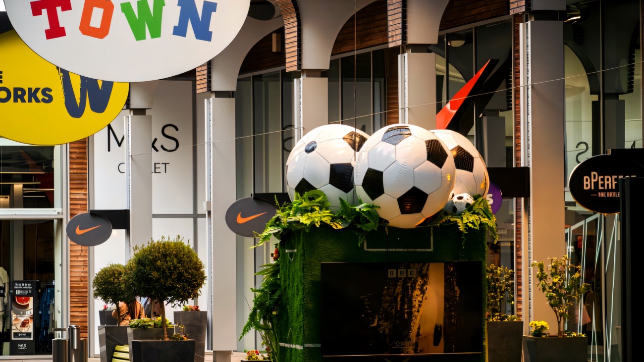 The summer football fan zone set up on the mall street at The Boulevard, with giant footballs and deckchairs outside the Toytown and M&S Outlet stores
