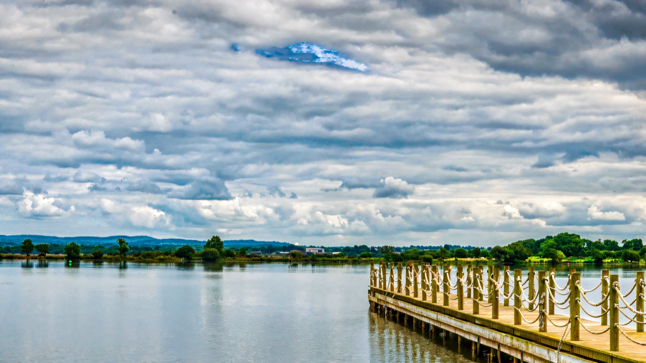 A rope-railed jetty reaching out into the wide lough