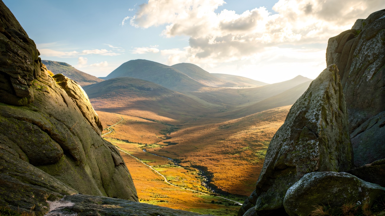 Granite slabs framing a view down the valley to the rounded Mourne summits beyond