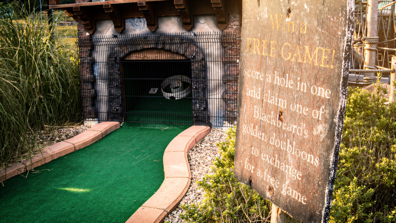 The cave-mouth hole with a sign telling players to score a hole in one and claim one of Blackbeard's golden doubloons