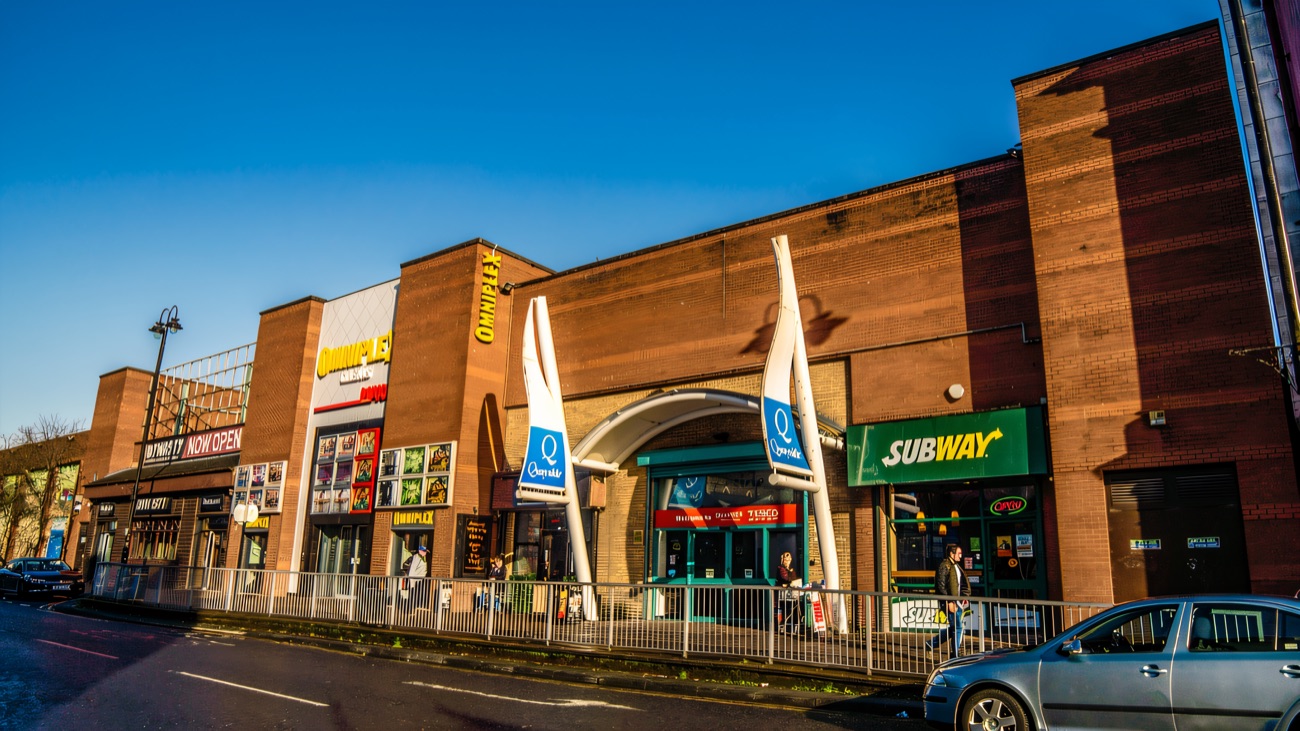 The Quayside frontage on a clear day — the blue entrance sails, the Omniplex cinema sign and the Subway on Strand Road