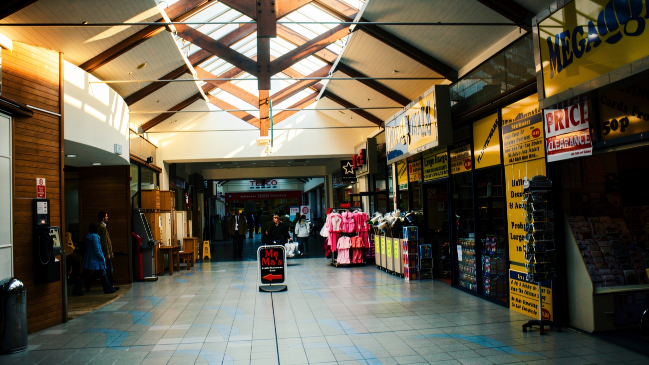 Inside the covered arcade at Quayside, the pitched glass-ridge roof running the length of the mall towards the Tesco superstore