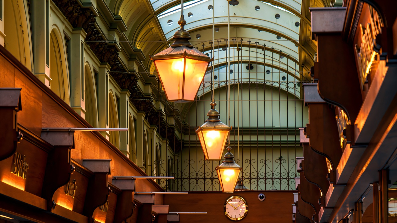 Looking down Queen's Arcade under the ornate ironwork and Victorian lanterns