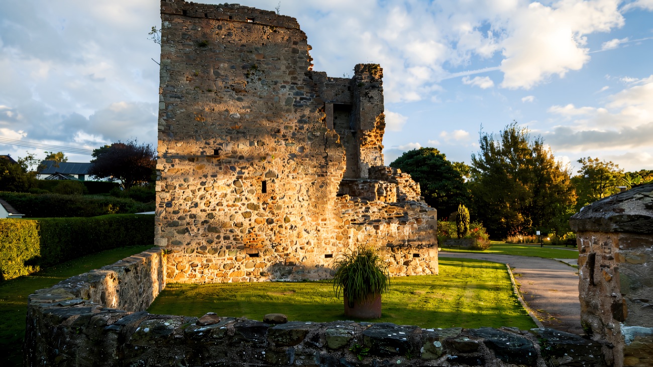 A tall view of the castle ruin, with its bare gable and empty windows against the sky