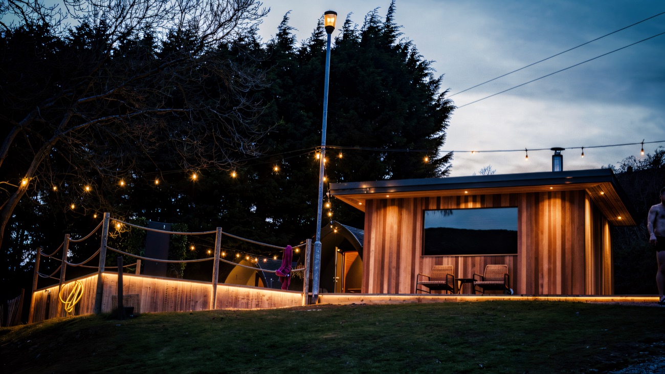 The cabin glowing warm at dusk under the Mournes