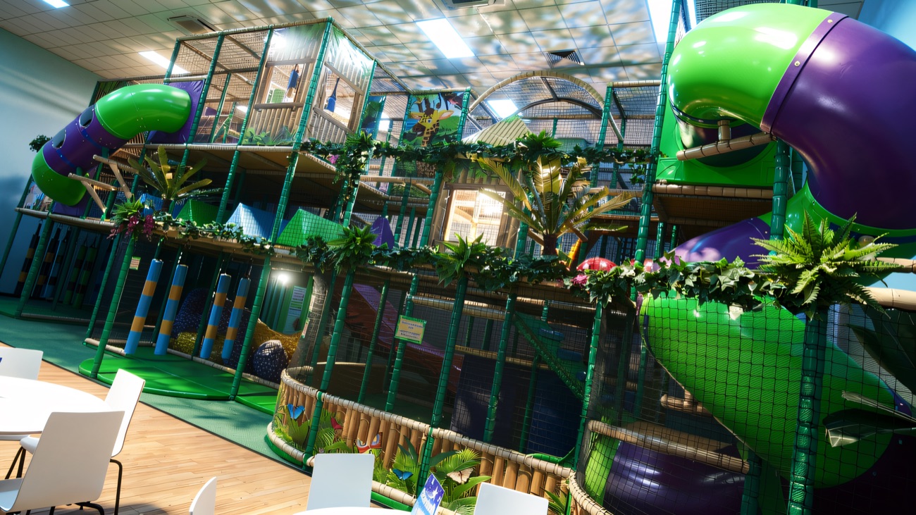 The big jungle-themed play frame with green and purple tube slides and leafy trim