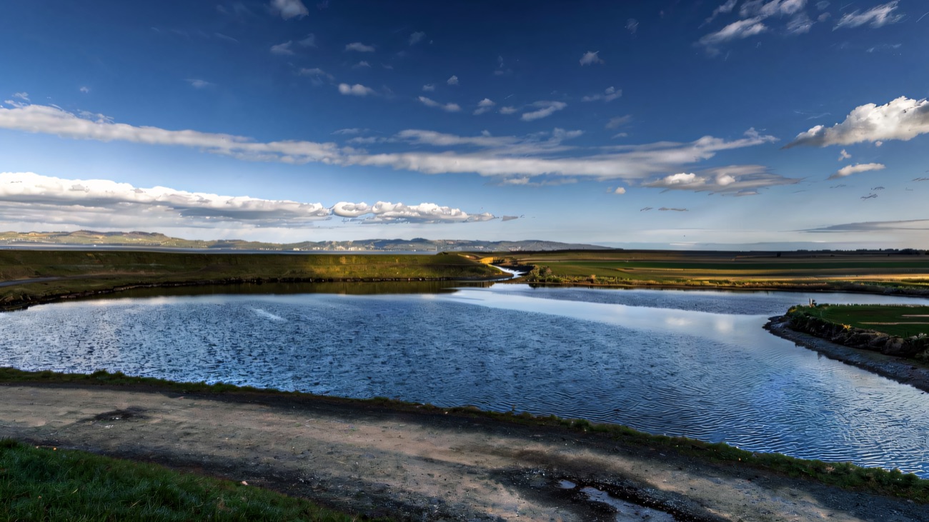 Still estuary water beside the walking path, the Donegal hills low on the horizon.