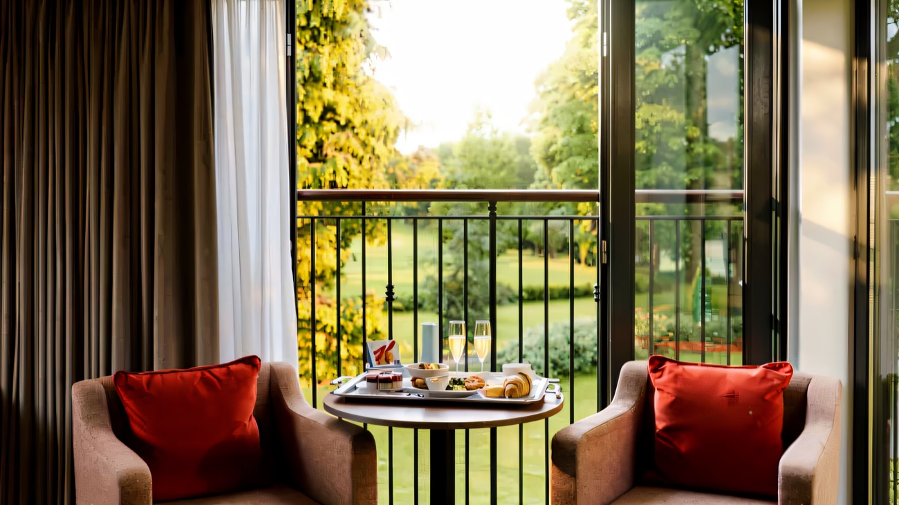 Two soft armchairs by a window looking out over the resort's green grounds.
