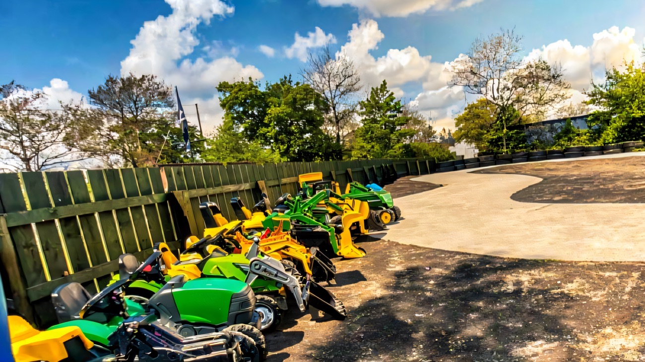 A row of ride-on toy tractors in the play yard