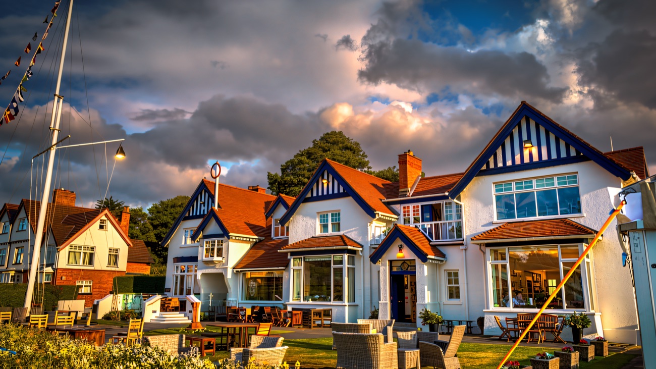 The bright blue-and-white clubhouse with its flag mast and sunlit terrace