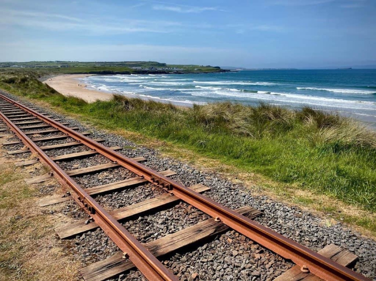 The heritage railway track running along the dune edge above Runkerry Strand, the beach and bay stretching away behind