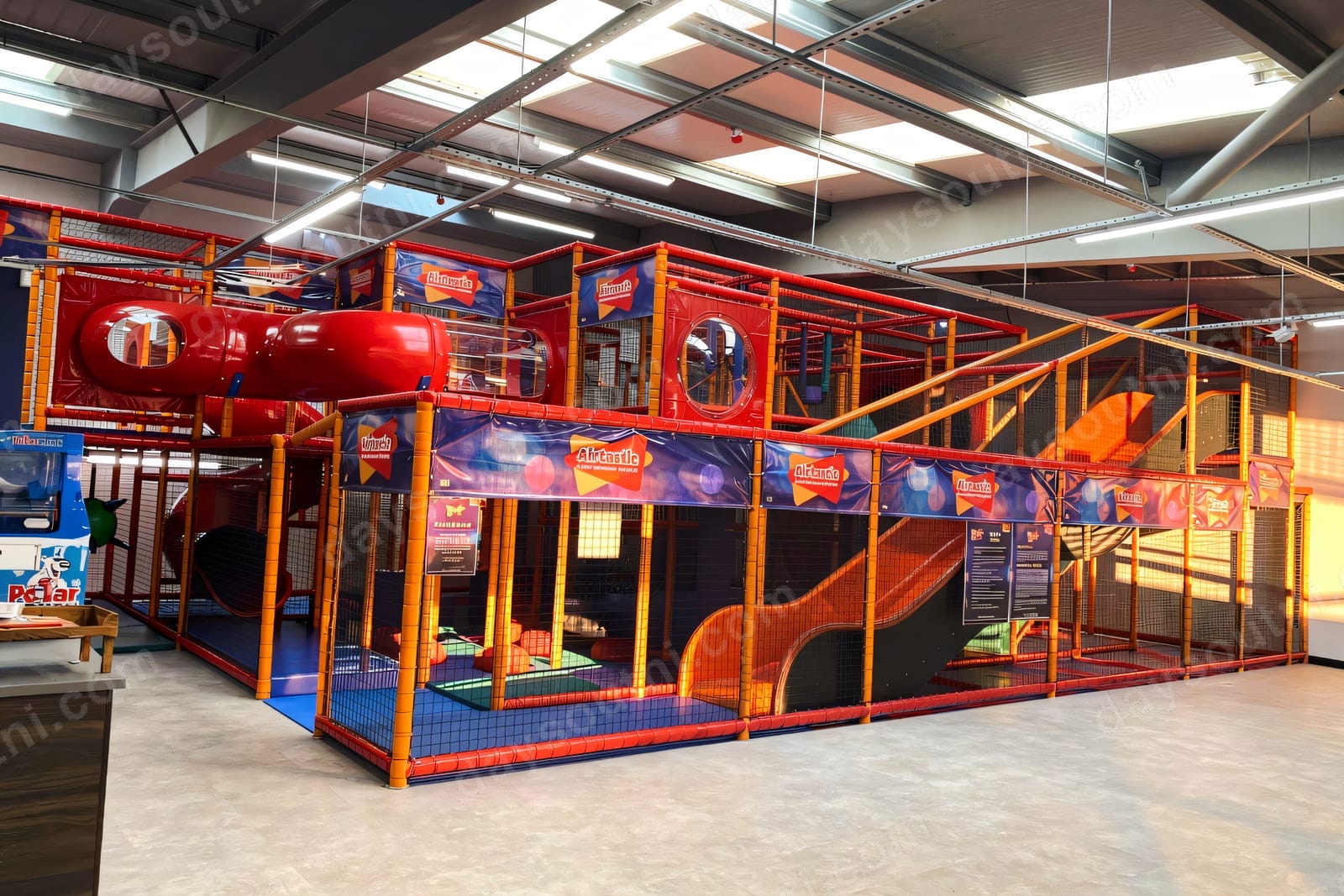 The multi-level orange-and-red 'Atlantis' soft play frame inside Airtastic Craigavon, with slides, tubes and netting