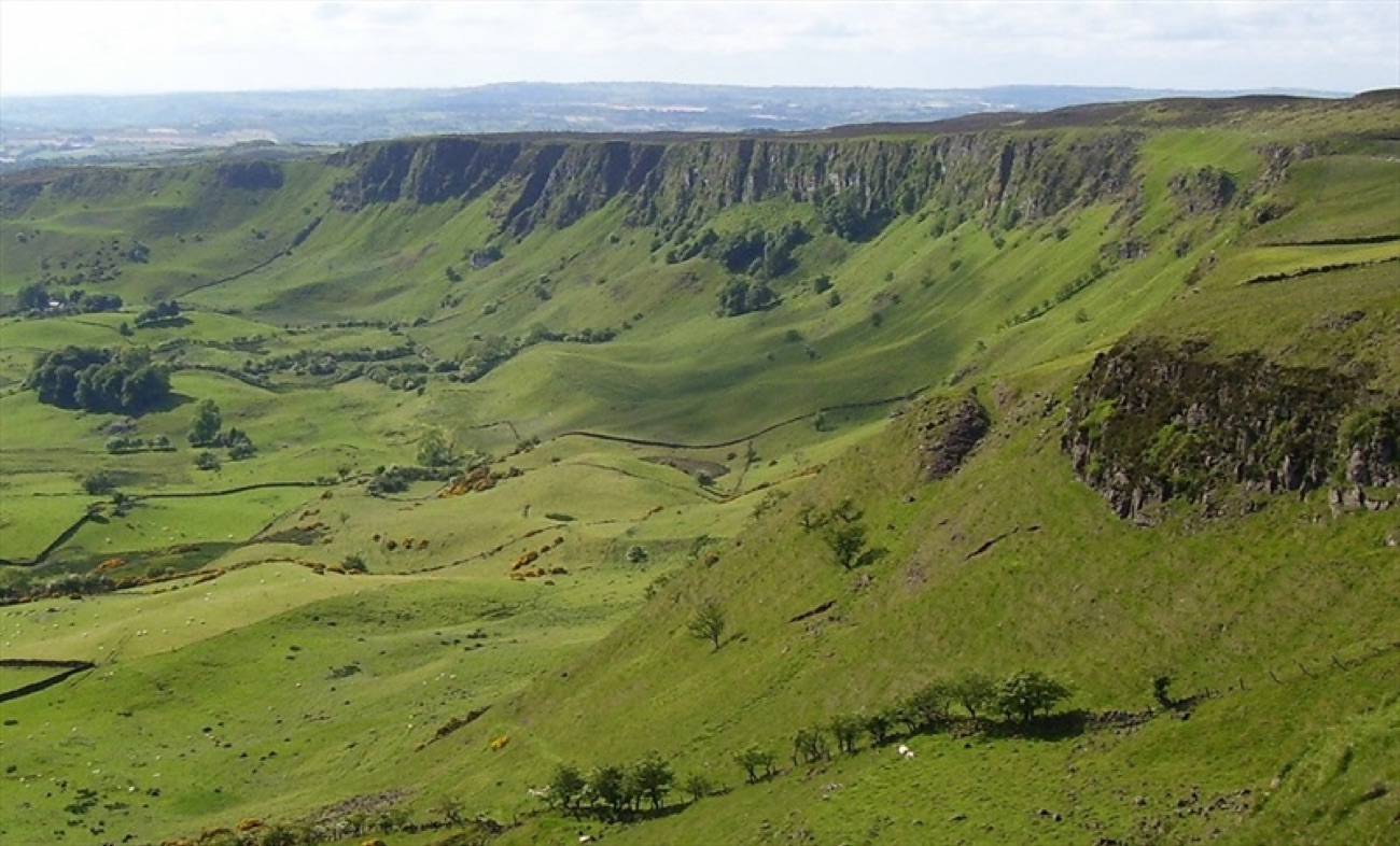 The sweeping green amphitheatre of steep cliffs curving round above sheep-grazed slopes