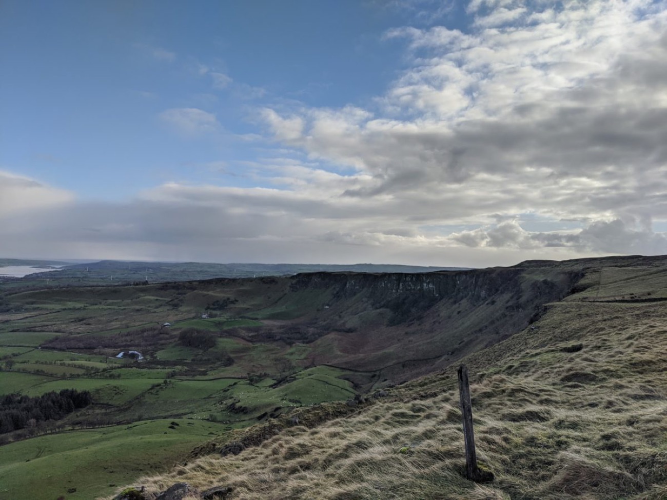 The basalt cliff edge of Sallagh Braes seen from the open hill walk with the valley below