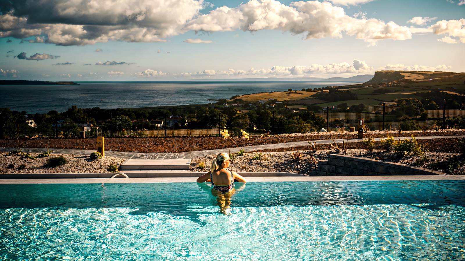 The outdoor infinity pool at Salt Spa, its edge blending into the Atlantic with Fair Head in the distance.