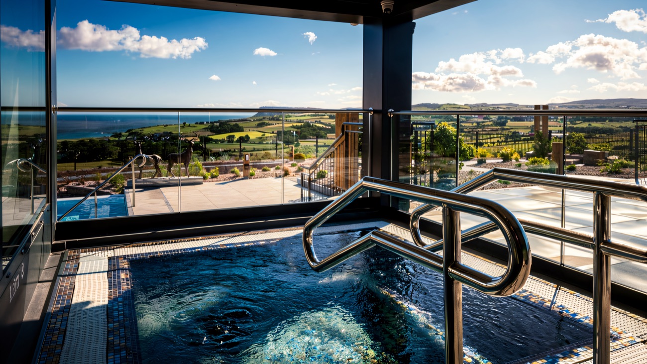 An outdoor bubbling vitality tub with an open view over the coastline and glens.