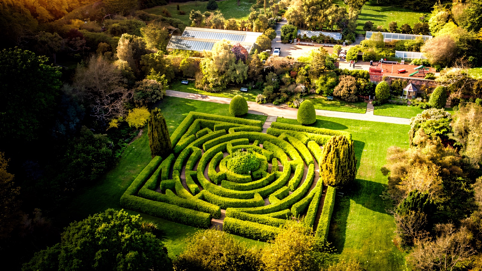 Aerial view of the circular hedge maze at Seaforde Gardens with the glasshouses and demesne behind