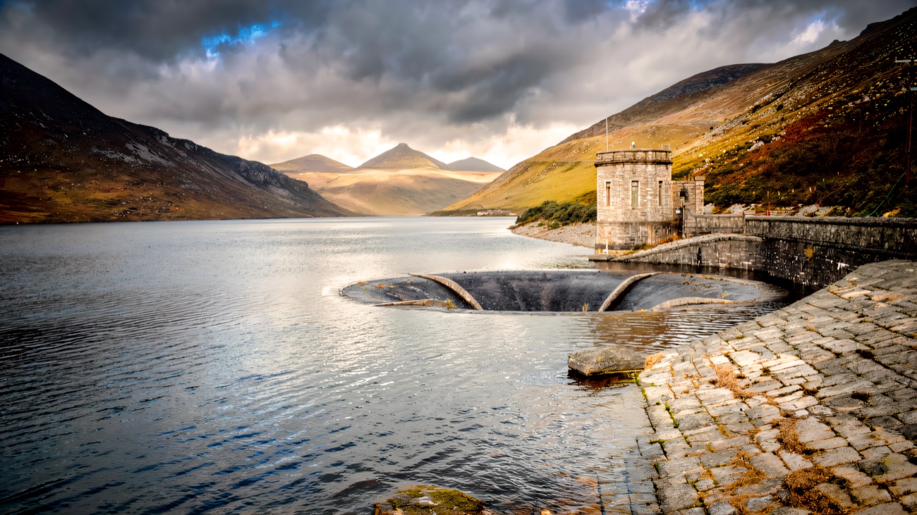 Storm light over the dam wall and the deep dark reservoir