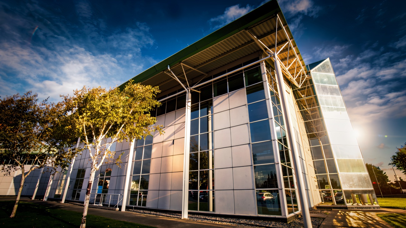 The glass front of Sixmile Leisure Centre against a blue sky
