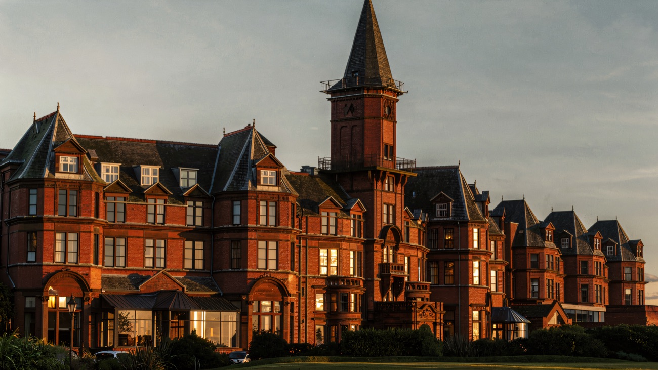 Evening light on the hotel's clock tower and gabled roofline above the seafront.
