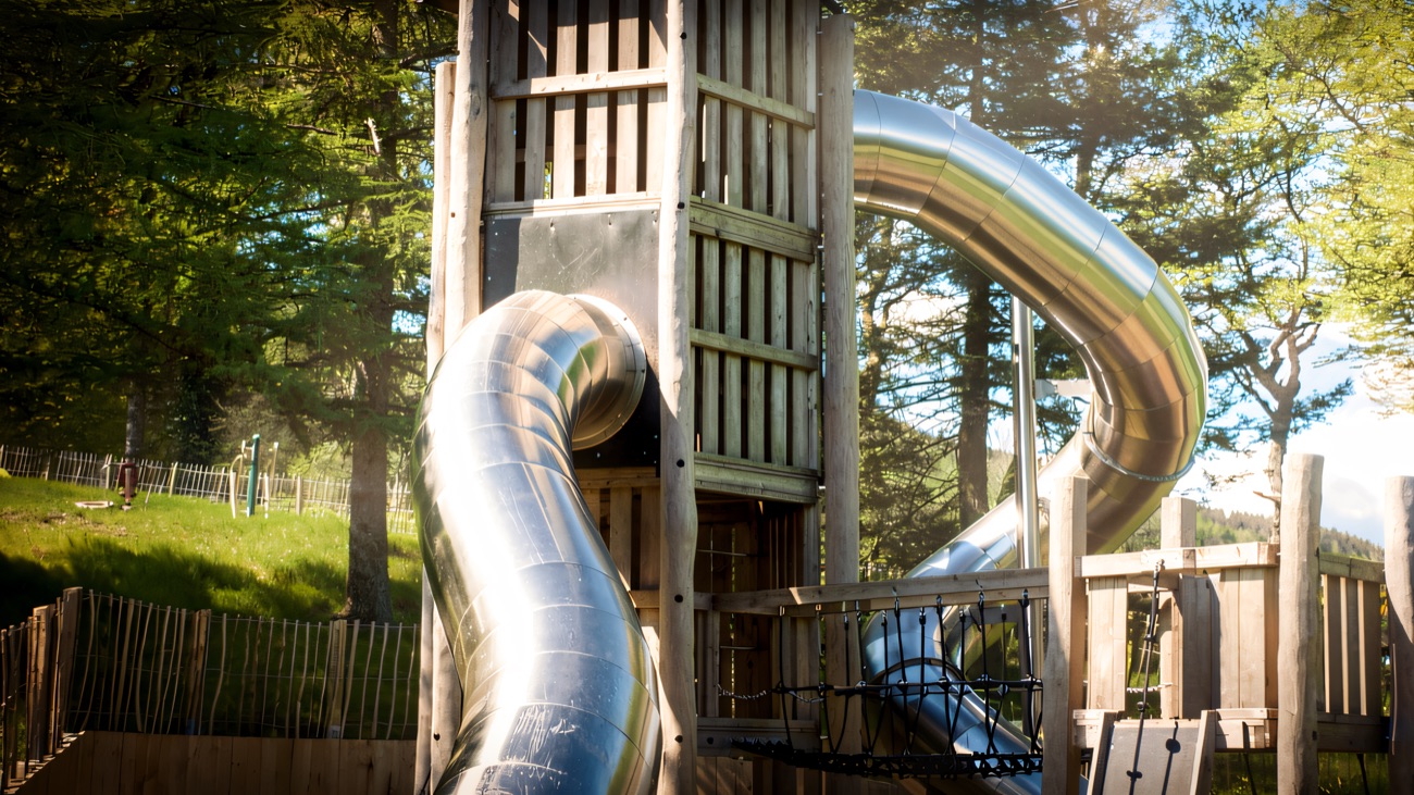 The tall wooden climbing tower with twin curving metal tube slides in the Slieve Gullion playpark