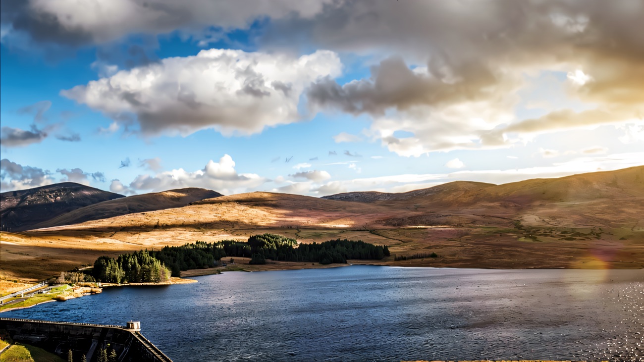 The dam wall and reservoir with the rounded flanks of the Mournes rising behind