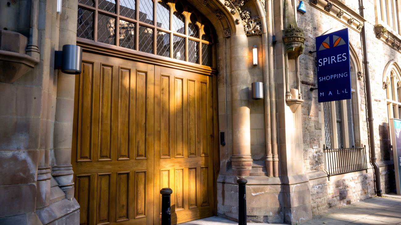 The old Spires Shopping Mall entrance set into the Gothic stone archway of Church House