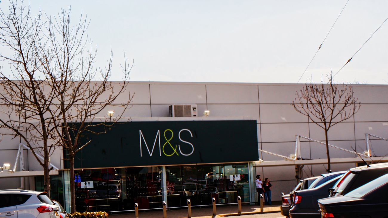 The dark green M&S sign over the anchor store's entrance at Sprucefield Centre, seen across the car park