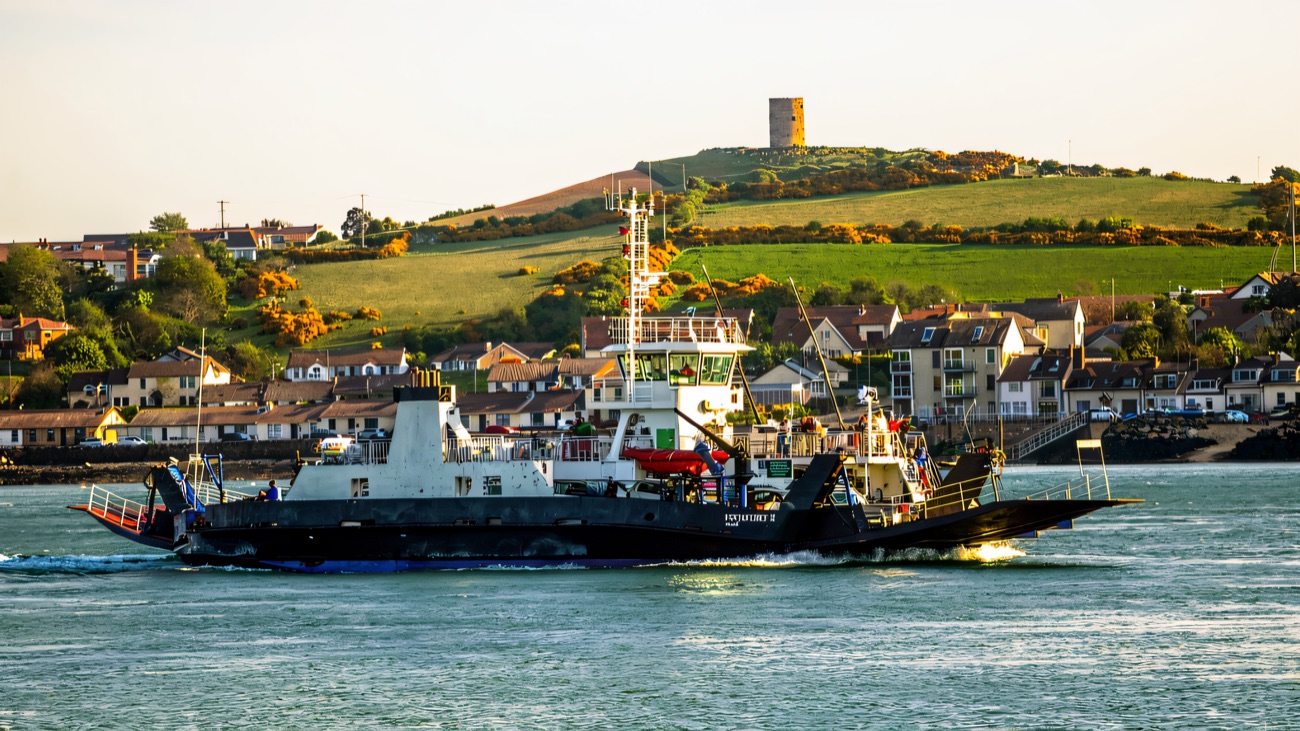 The Portaferry car ferry crosses the Narrows below the town and its old windmill on the hill