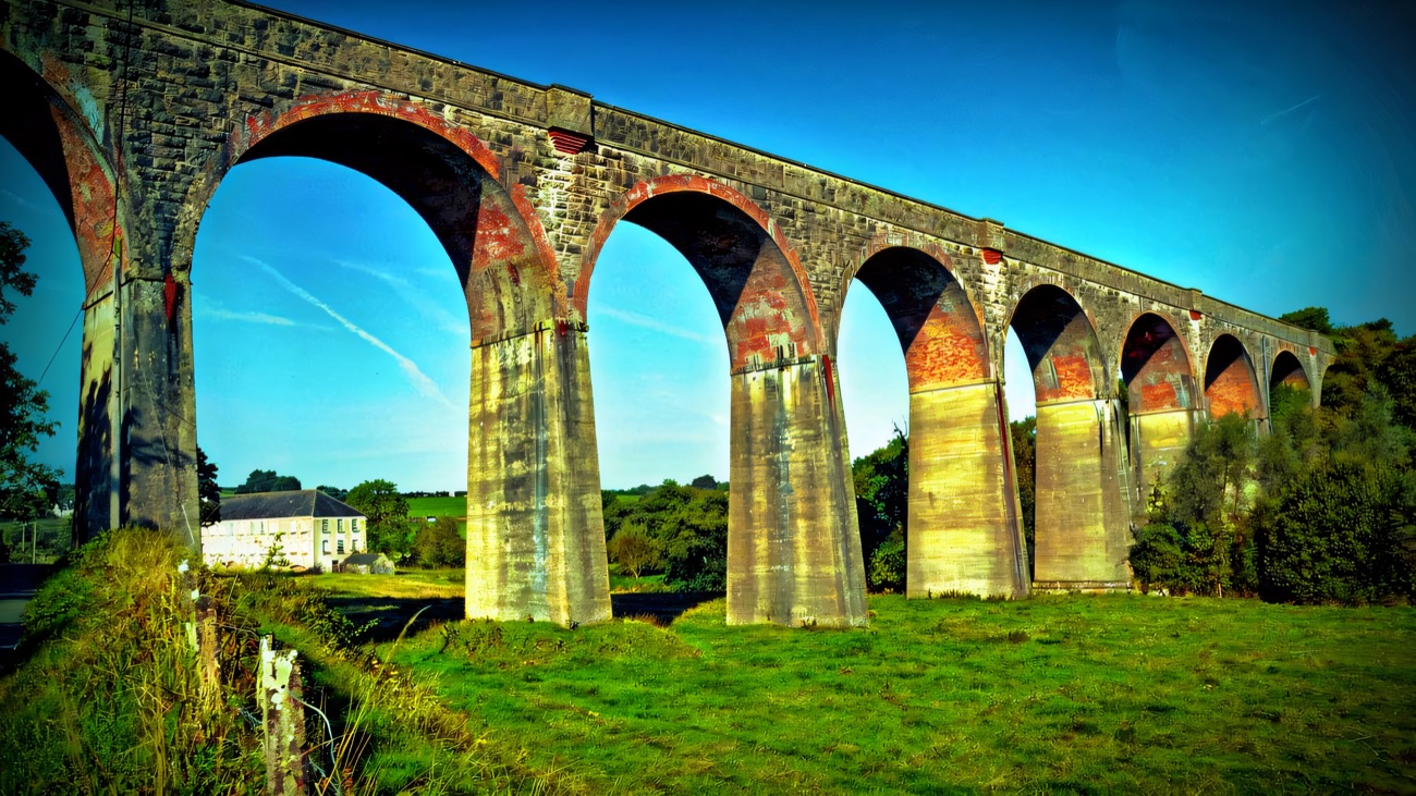 The great arches of the old railway viaduct striding across the valley.