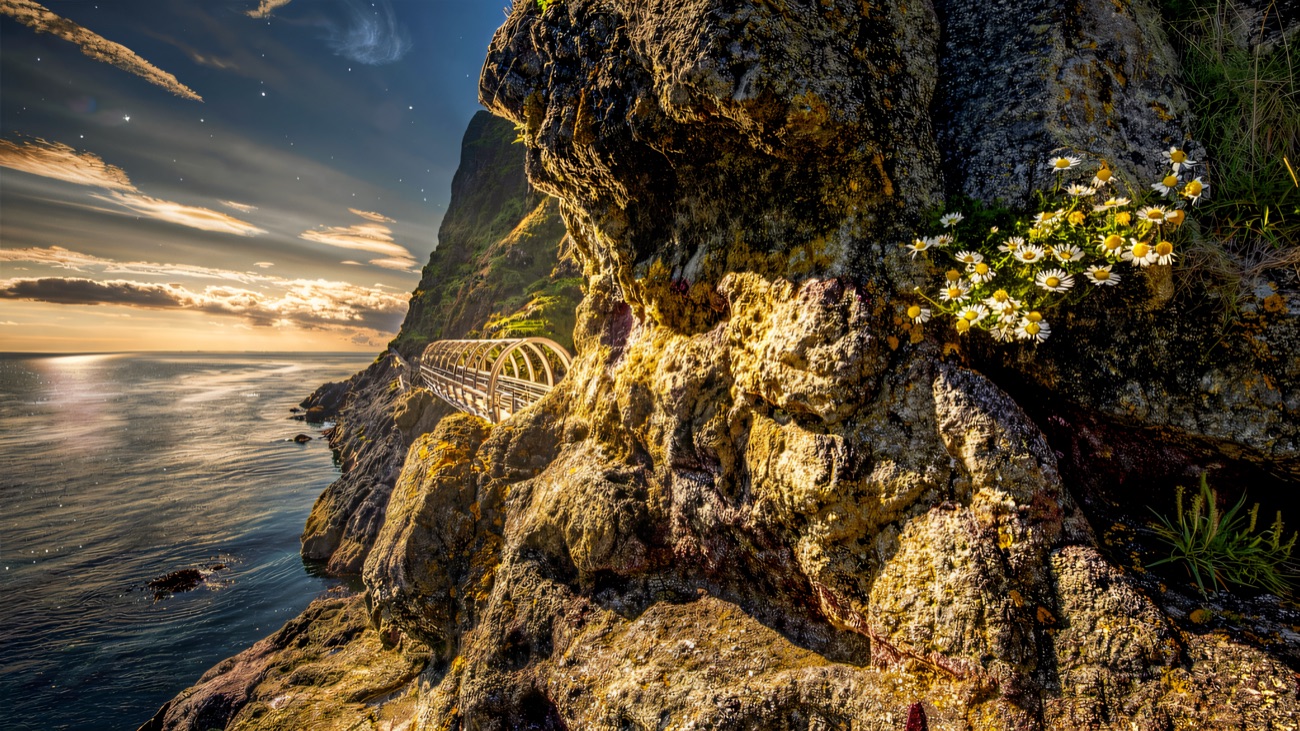 The famous tubular bridge tucked into the rock, wildflowers clinging on