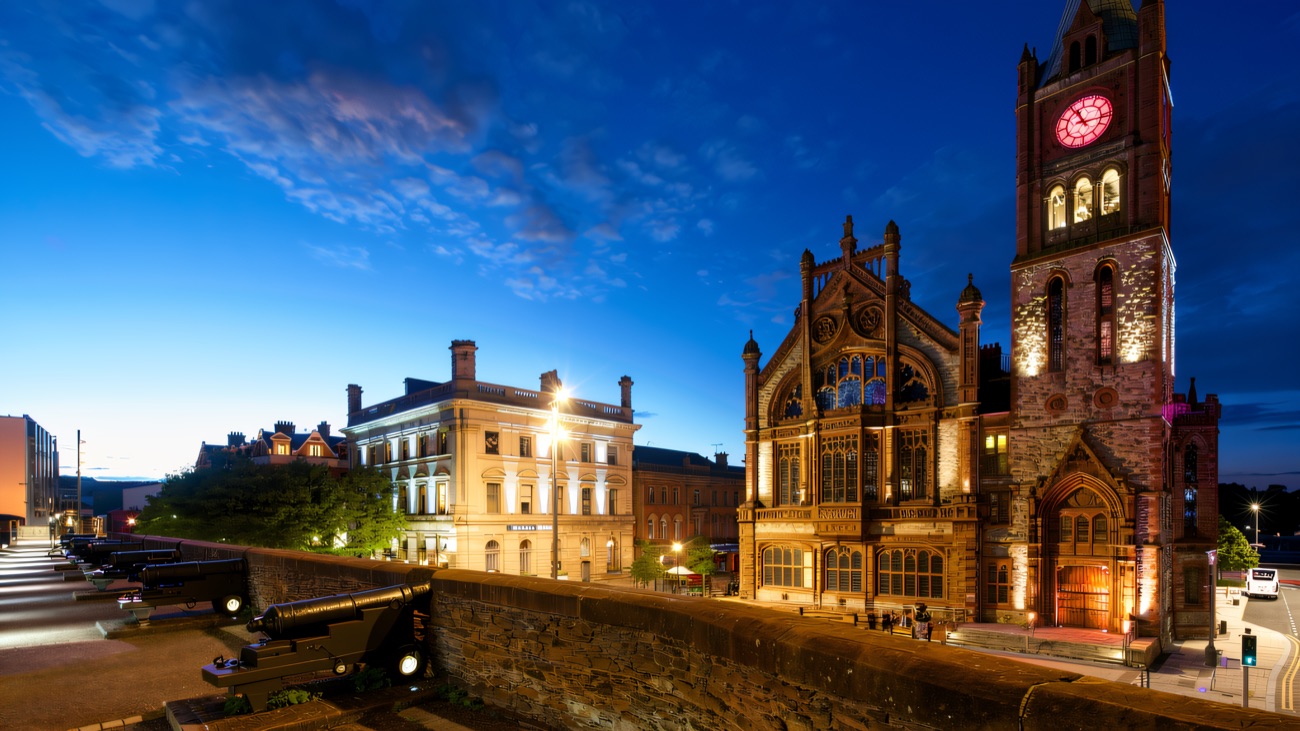 The floodlit Guildhall beside the cannons on the city walls