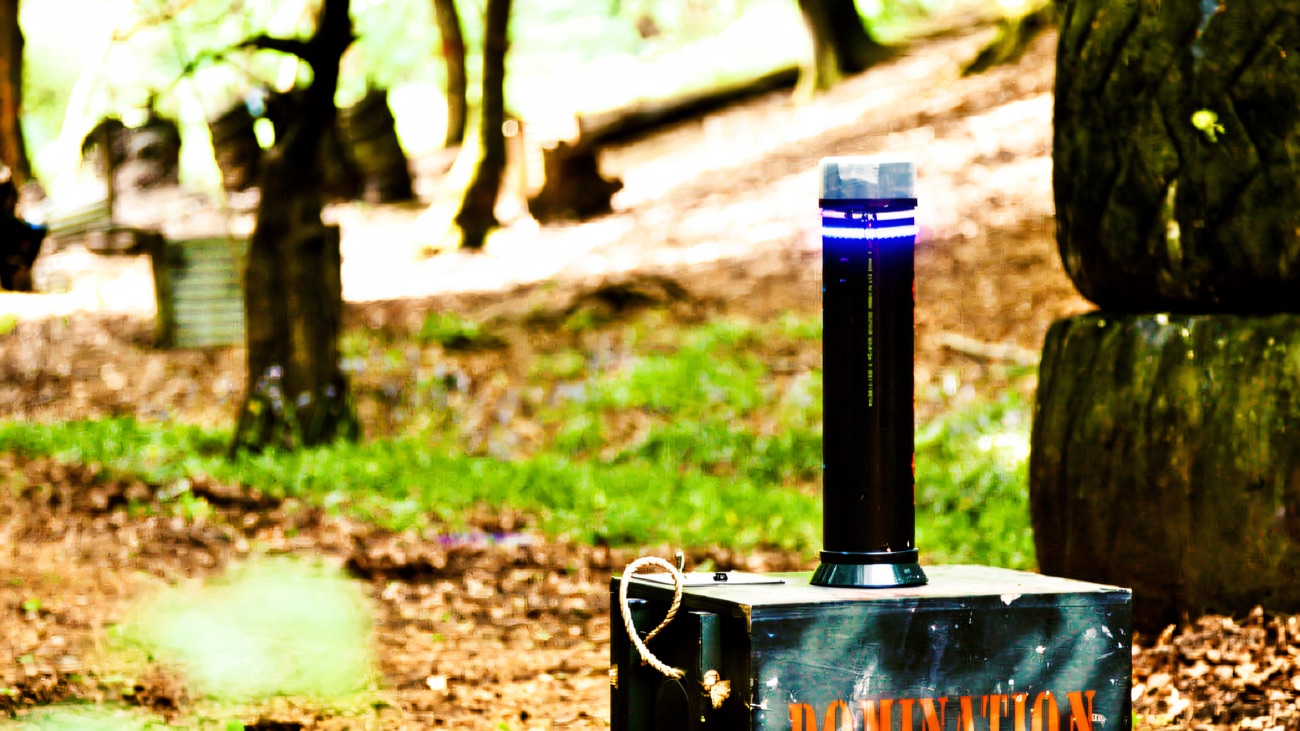 A wooden 'Domination' point with its blue light, set among the trees