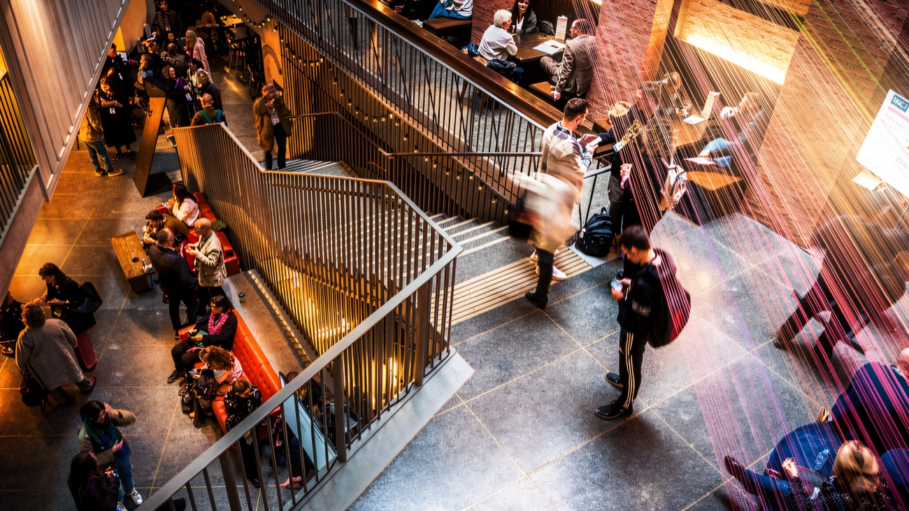 Visitors moving through the busy central staircase and foyer