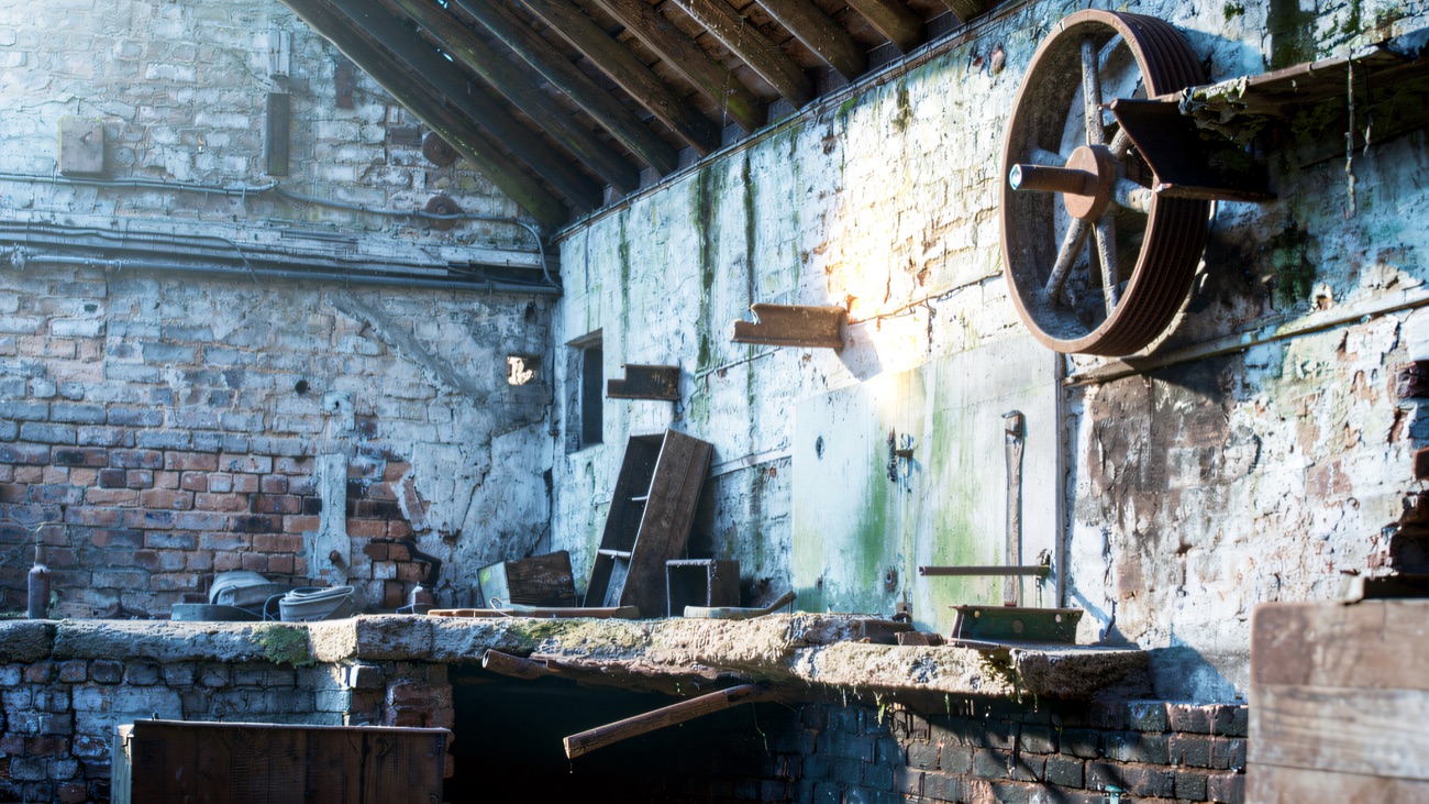 The old mill interior with its bare brickwork and cast-iron flywheel