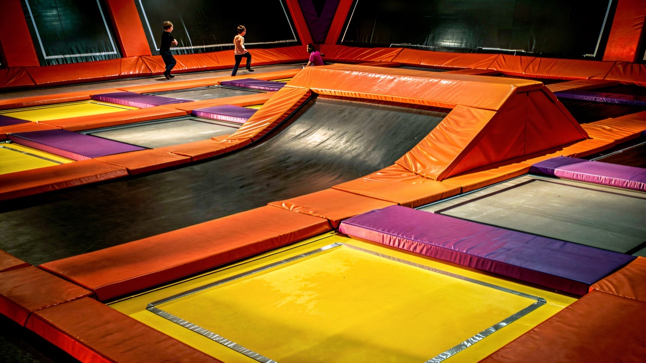 Jumpers bouncing across the big orange trampoline arena at Infinity Adventure Park