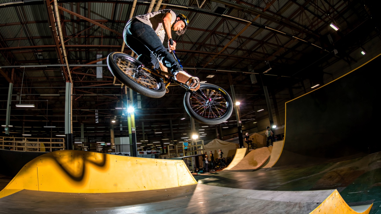 A BMX rider flying over the indoor ramps