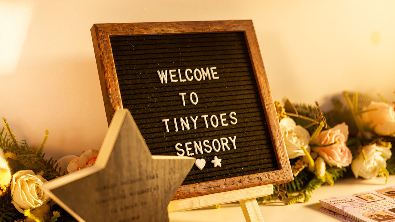 A welcome letterboard on the front desk, framed by dried flowers