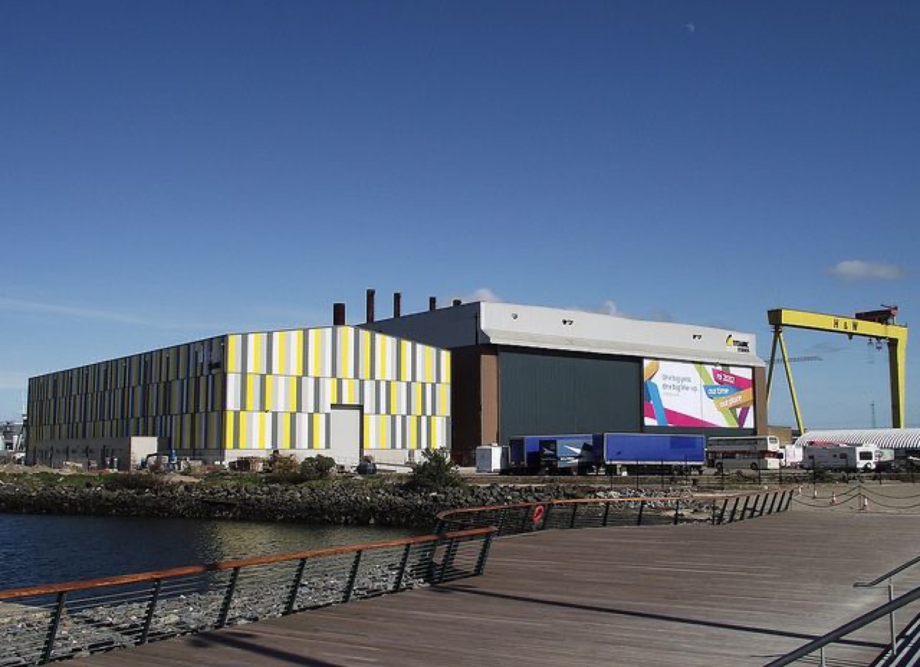 The studios building under a bright blue sky beside the water in the Titanic Quarter
