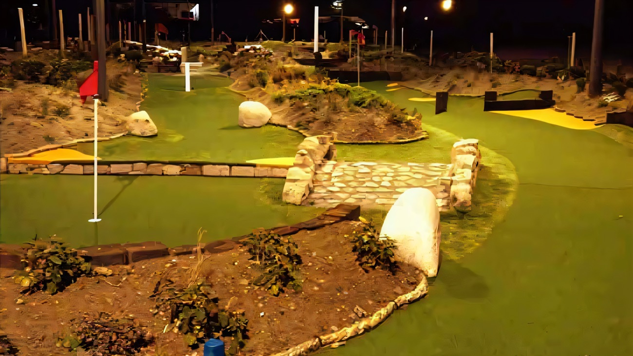 A stone bridge and boulder features lit up on the floodlit evening course