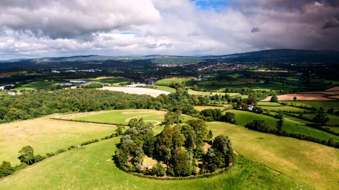 The tree-ringed hilltop fort above Cookstown, seat of the O'Neill chiefs, seen on a bright summer day.