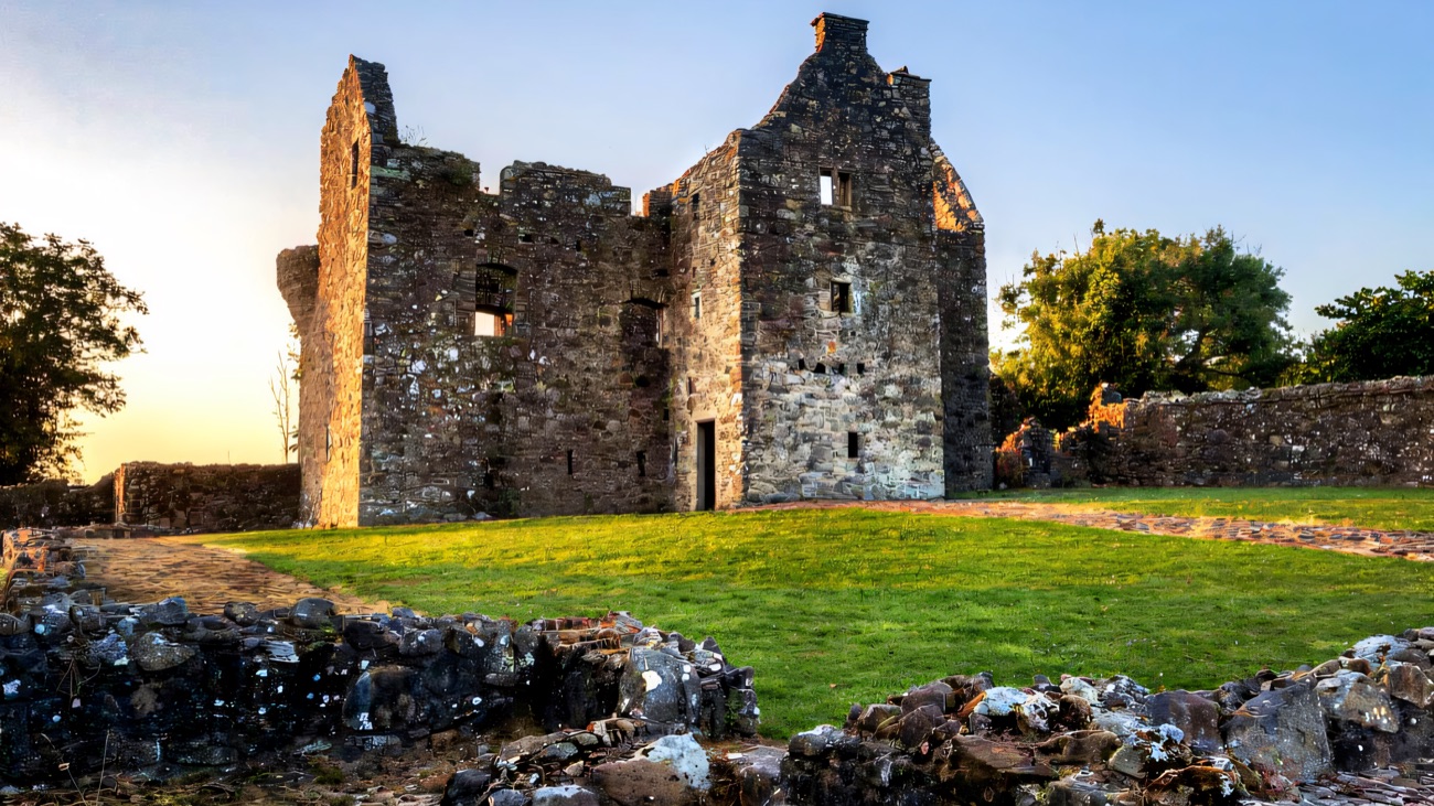 The ruined Tully Castle tower house and bawn walls in the low evening light