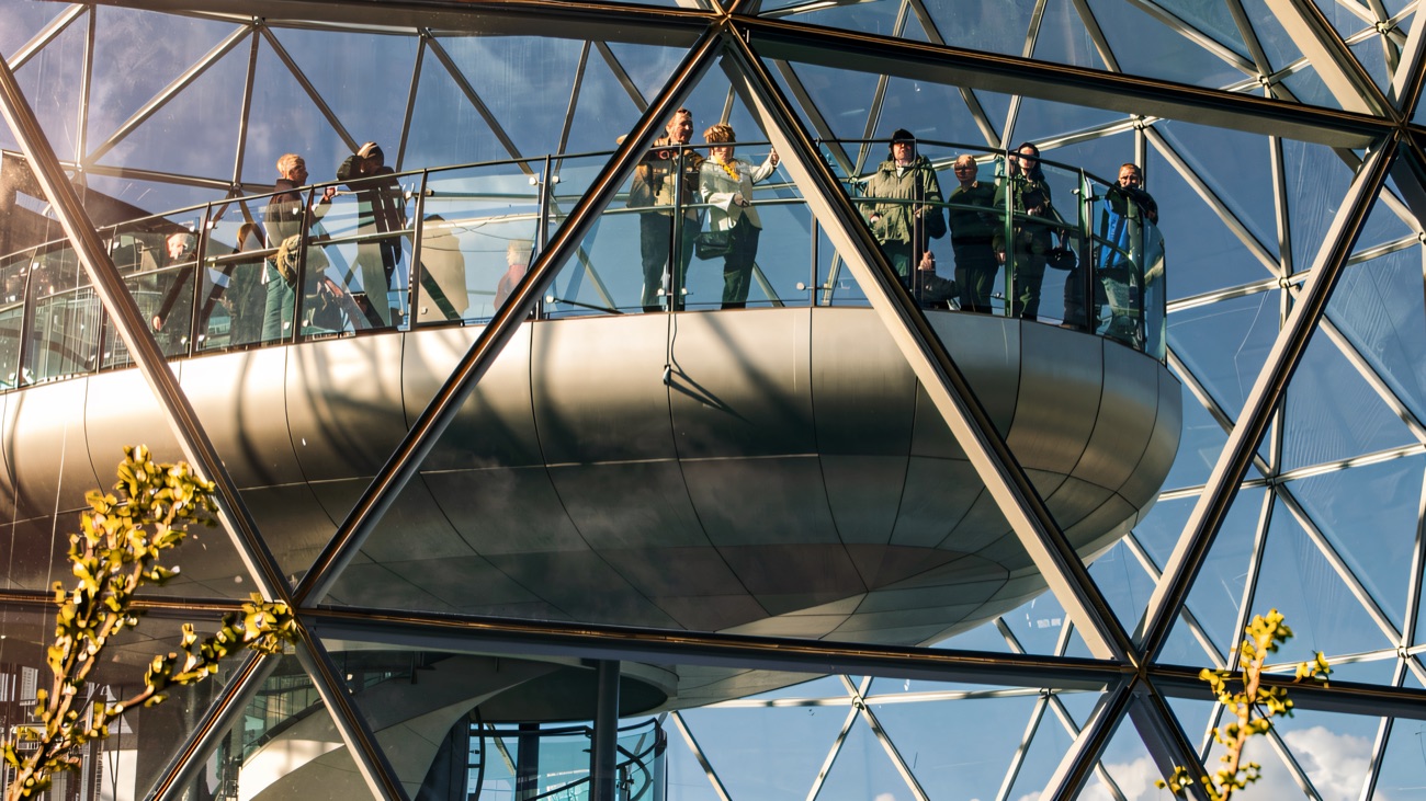 Visitors standing on the viewing gallery inside the glass dome at Victoria Square, high above Belfast