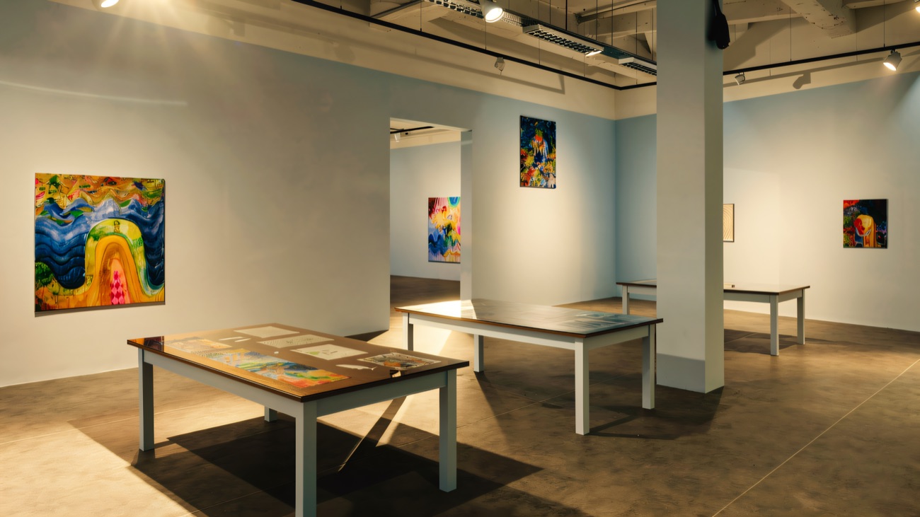 Colourful paintings and display tables in Void's main gallery