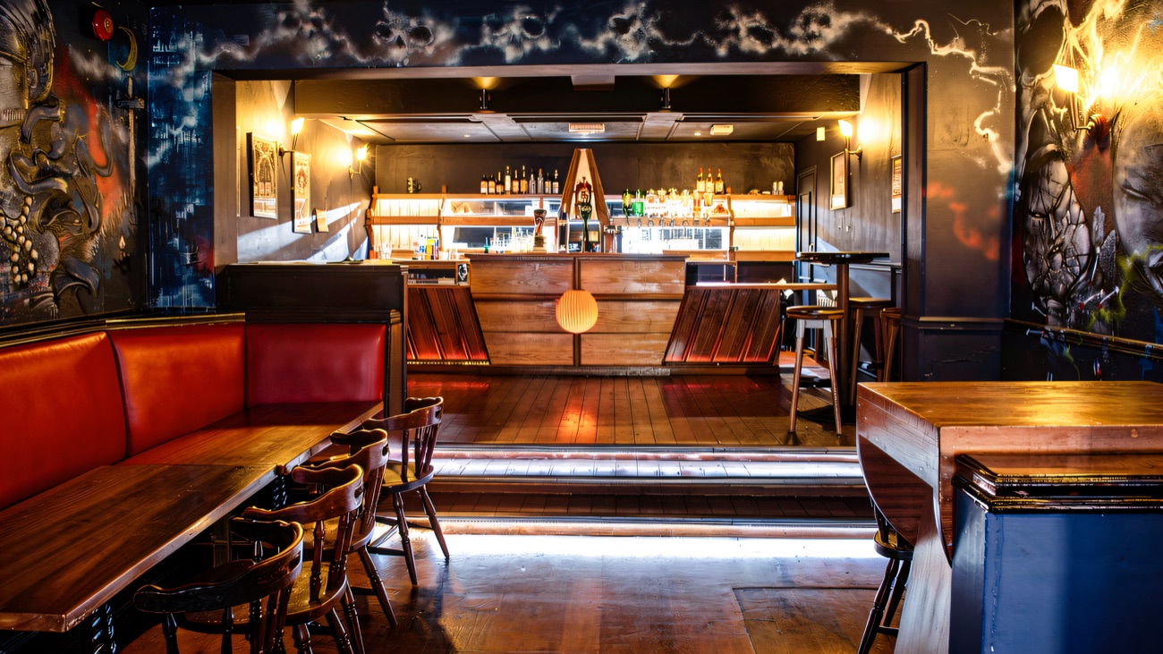 The main room with painted murals, red booths and the bar at the back