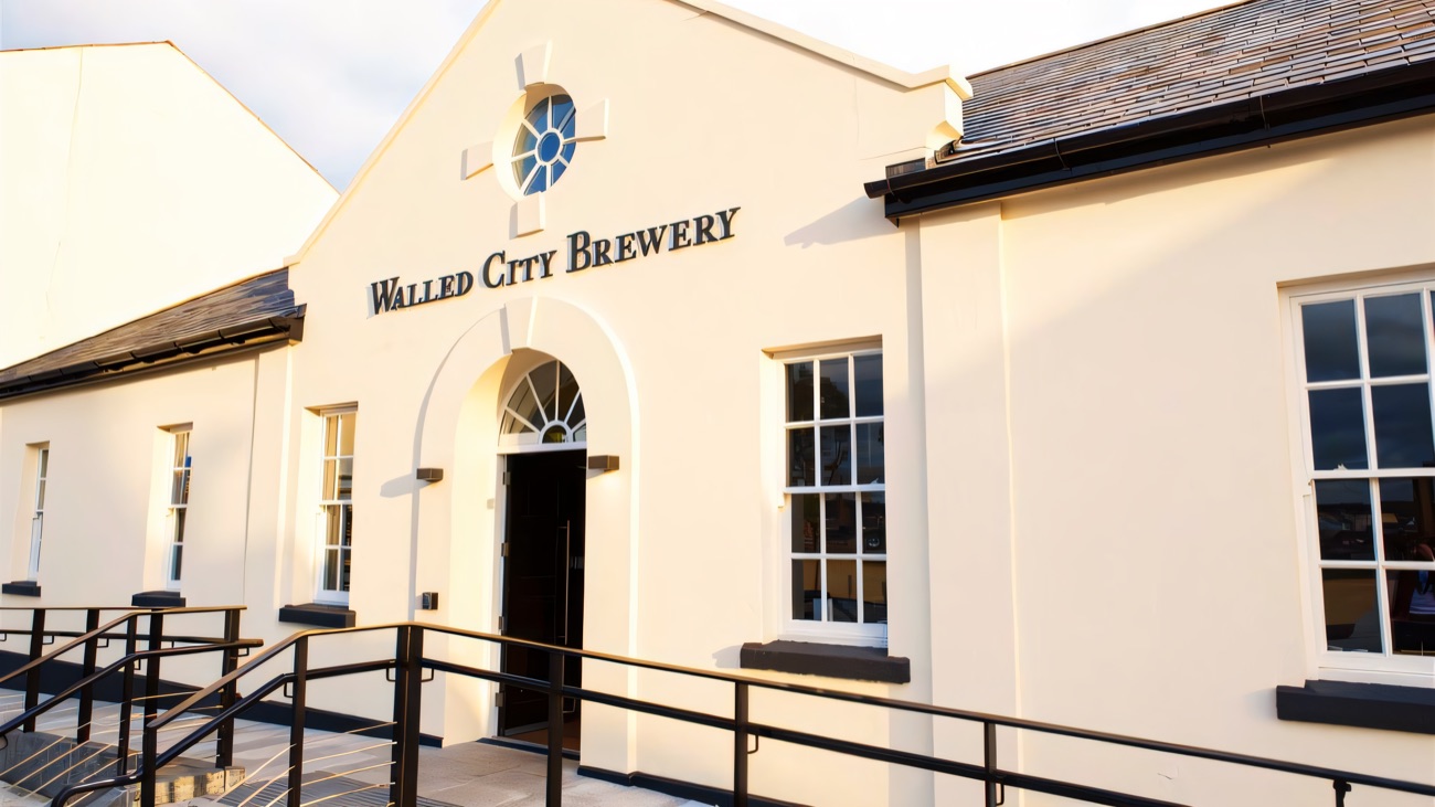The cream-painted brewery building with its name above the arched front door and a ramped entrance.