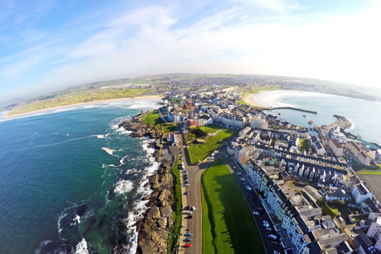 Wide aerial of the Portrush peninsula showing West Strand, the harbour and the town on the headland
