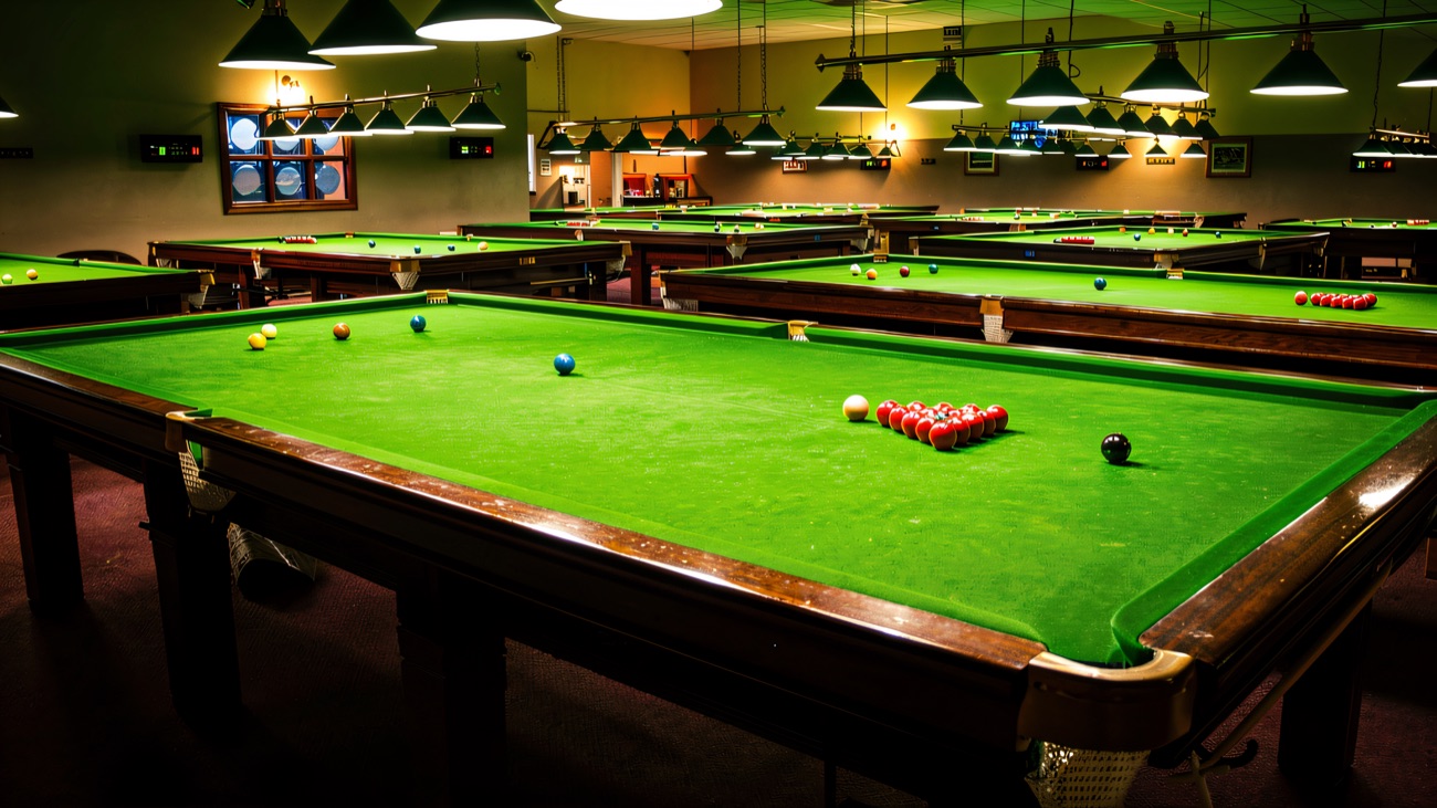 Rows of full-size snooker tables under the low green lamps at Westway