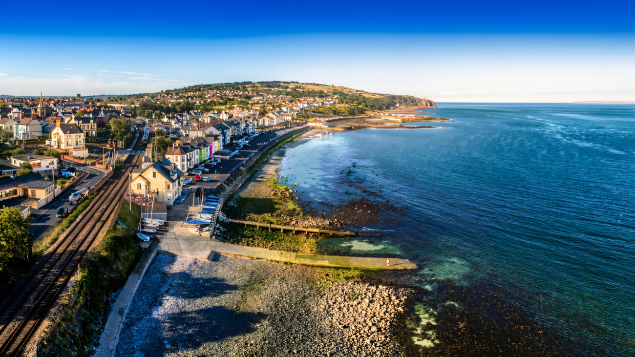 Aerial view along the promenade and concrete slipway, the railway line running behind the seafront houses
